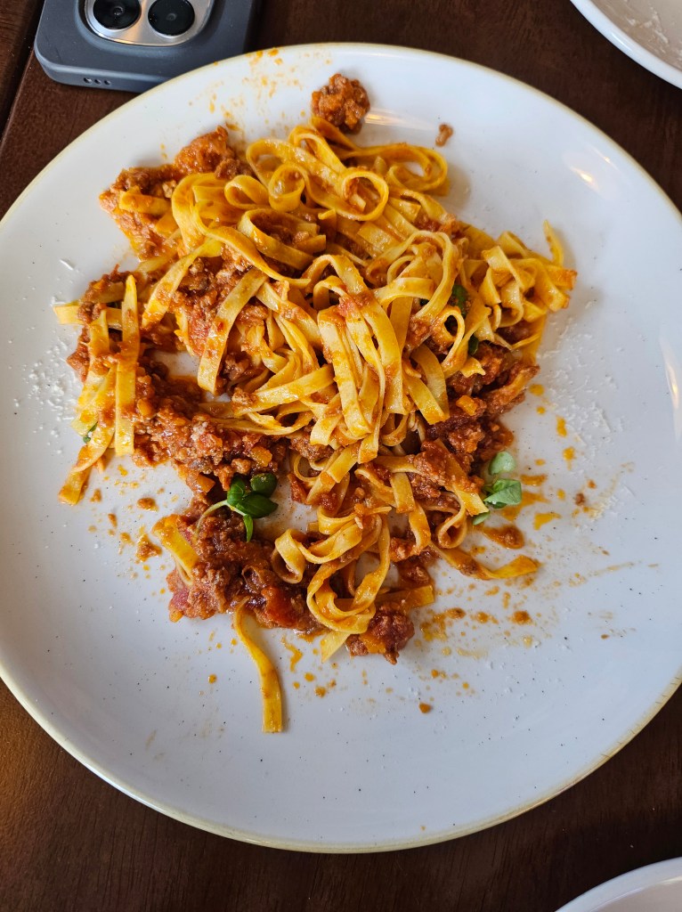 tagliatelle with ragu on a hite plate